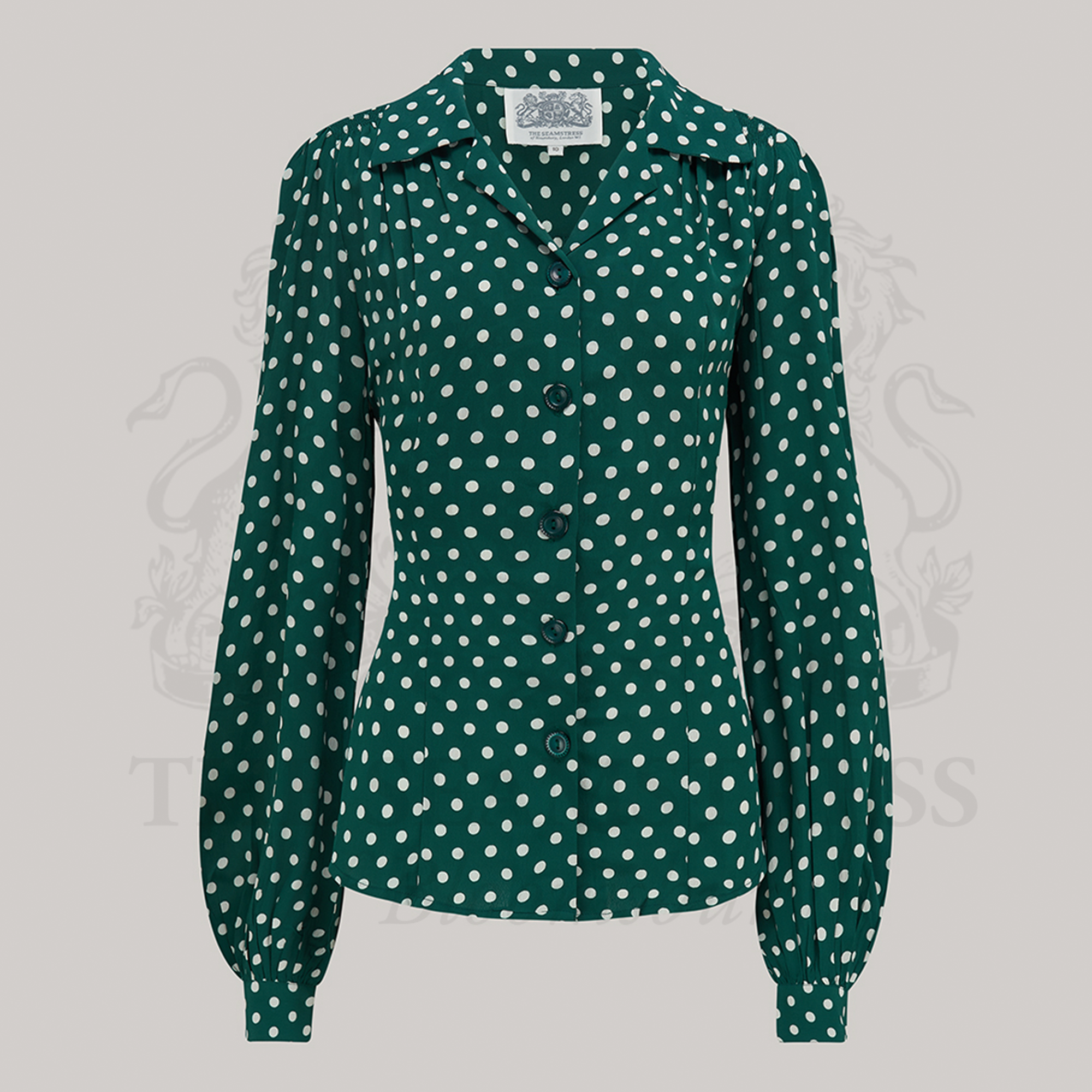 A green polka dot blouse with a revere collar, long sleeves with full cuffs, and shoulder pads. 