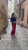 Model wears ide-leg 1940s women’s trousers in burgundy paired with a navy cable knit cardigan accessorised with a classic 1940s rolled hairstyle and t-bar shoes. Four decorative buttons are down the left from the waist with a hidden zip in the side seam. 