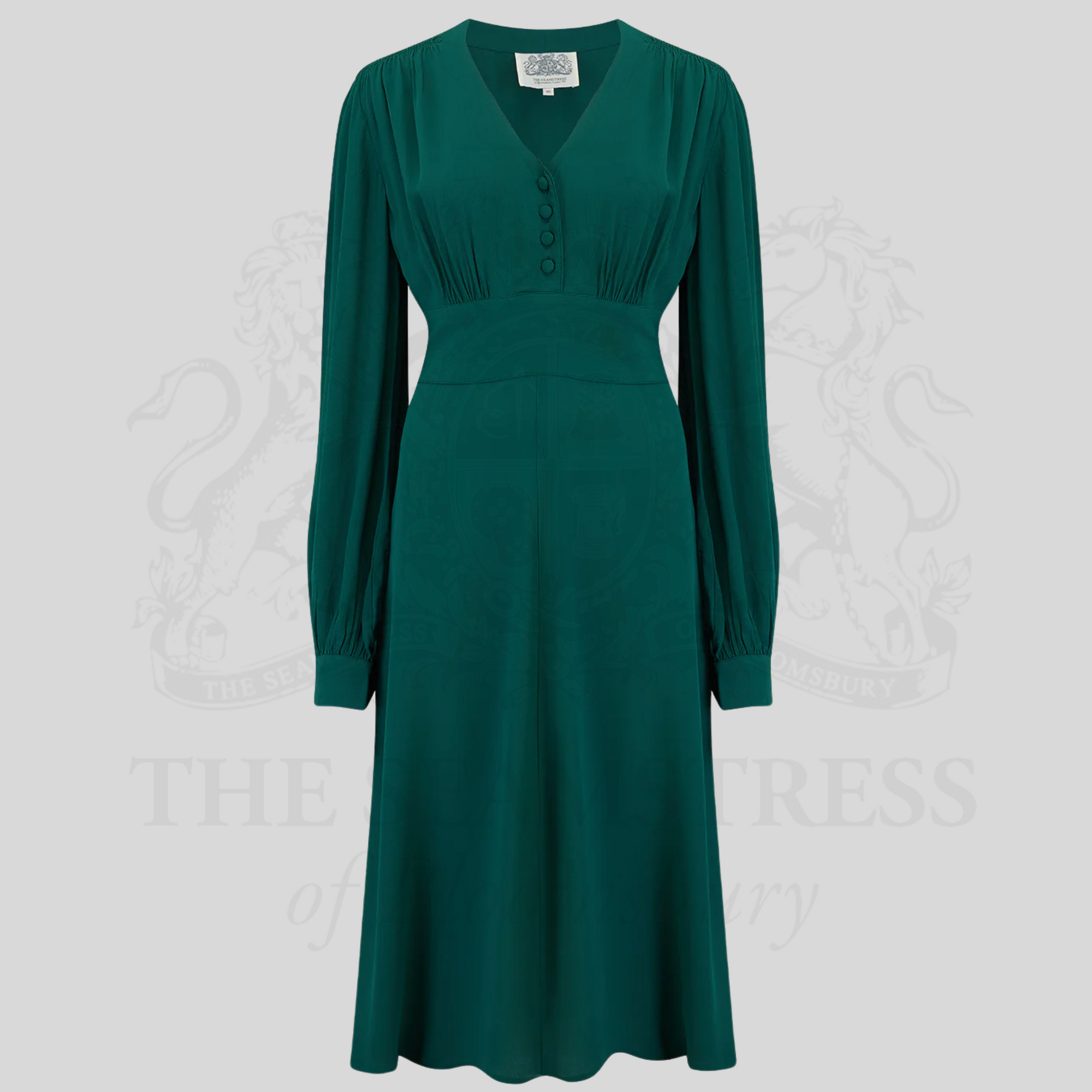A 1940s-style long-sleeve dress in green. Featuring gauged-in top yoke detailing on the shoulders and sleeves that puff out fully at the cuff. 