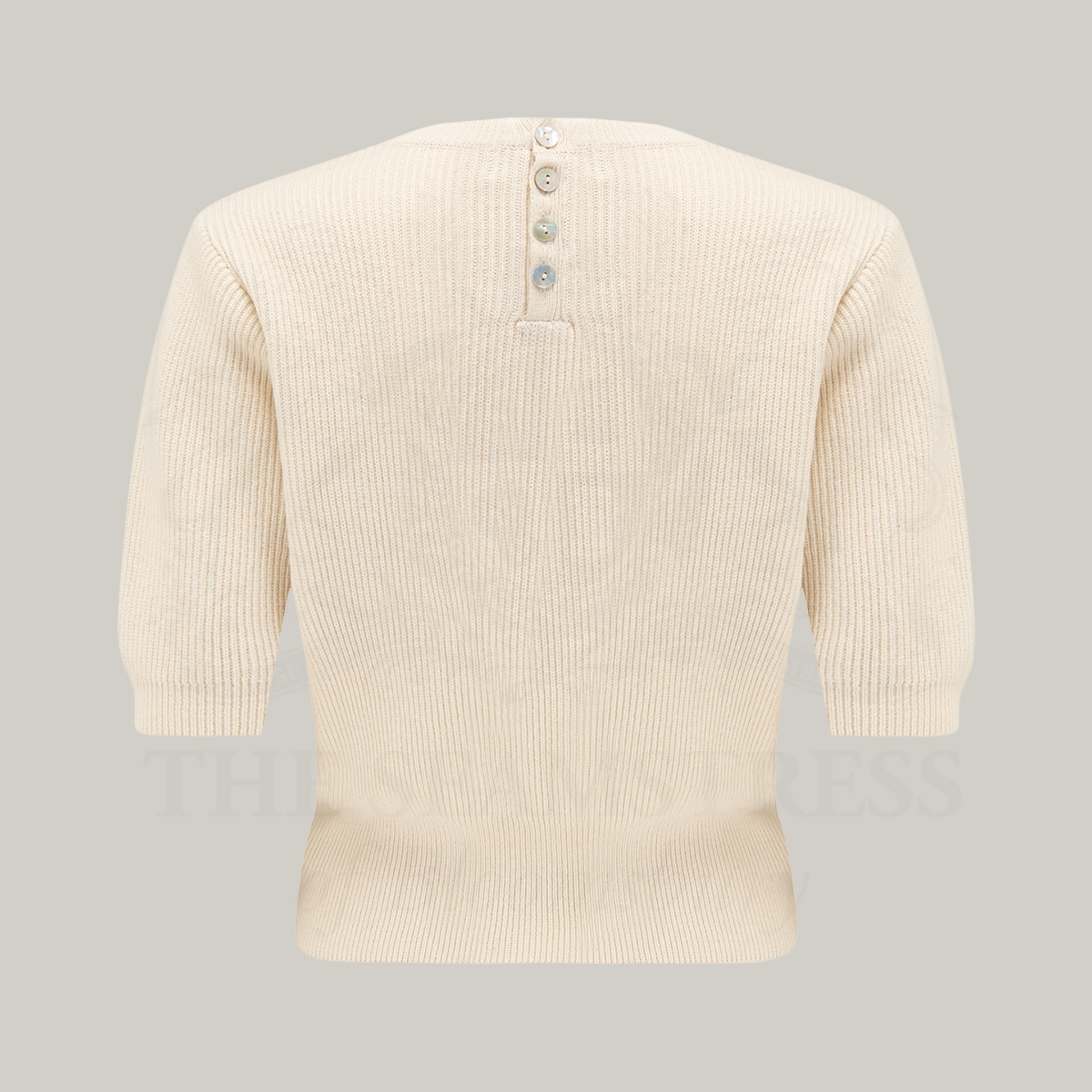 A knitted cream jumper with half-length sleeves and small figures along the chest. There are four buttons at the neck on the back of the jumper to fasten.