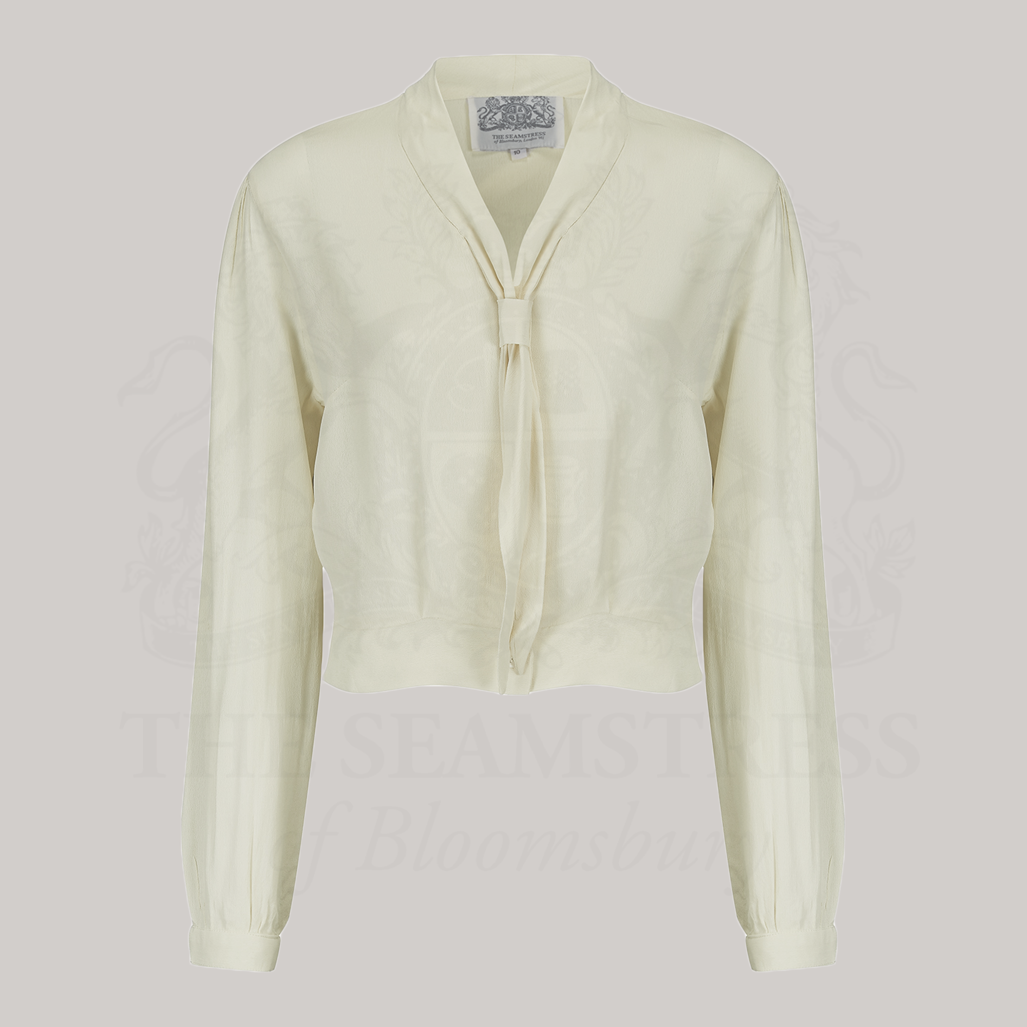 A 1940s sailor style blouse with long sleeves in cream. Featuring a roll style collar to give the iconic sailor look. Small buttons run down the front of the blouse for fastening but are hidden by the long collar.