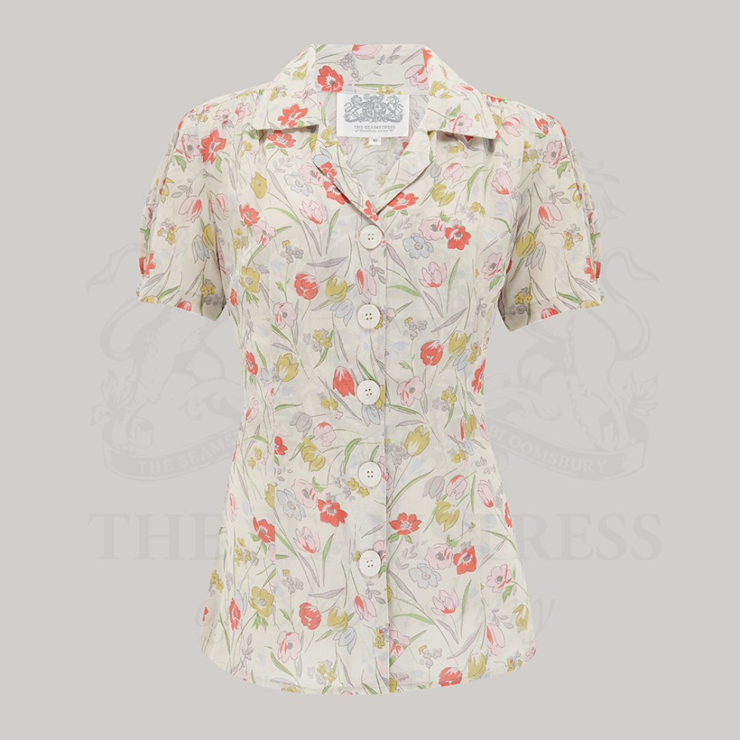A 1940s-style floral print blouse with a revere collar, short sleeves, and large bakelite buttons.